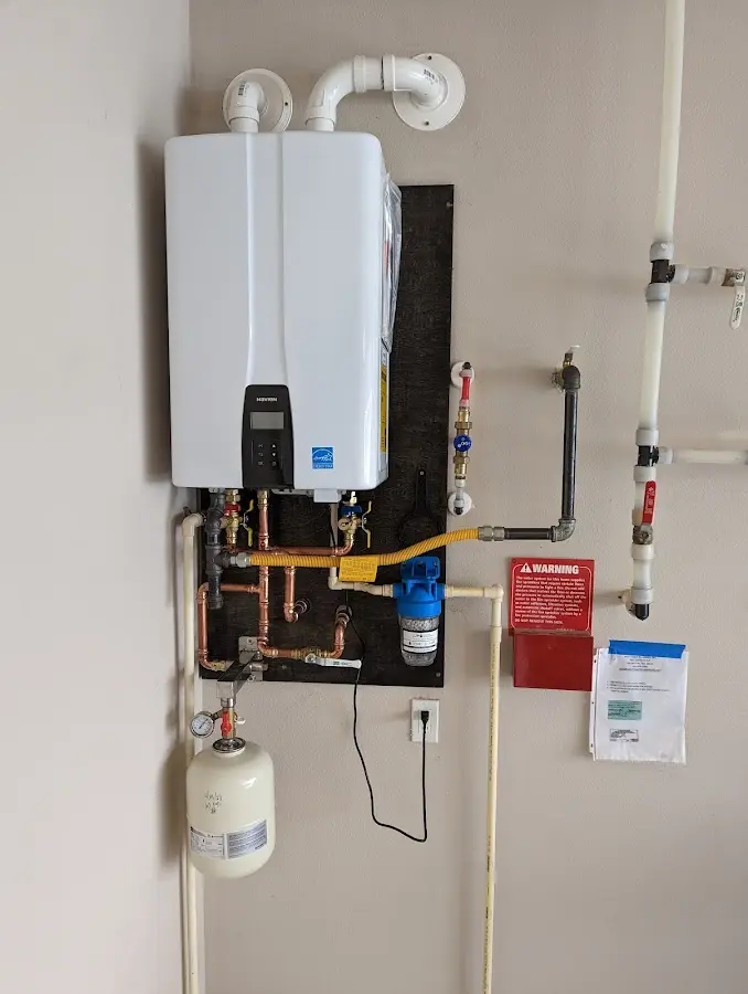 Professional plumber installing copper piping in a Wayland home